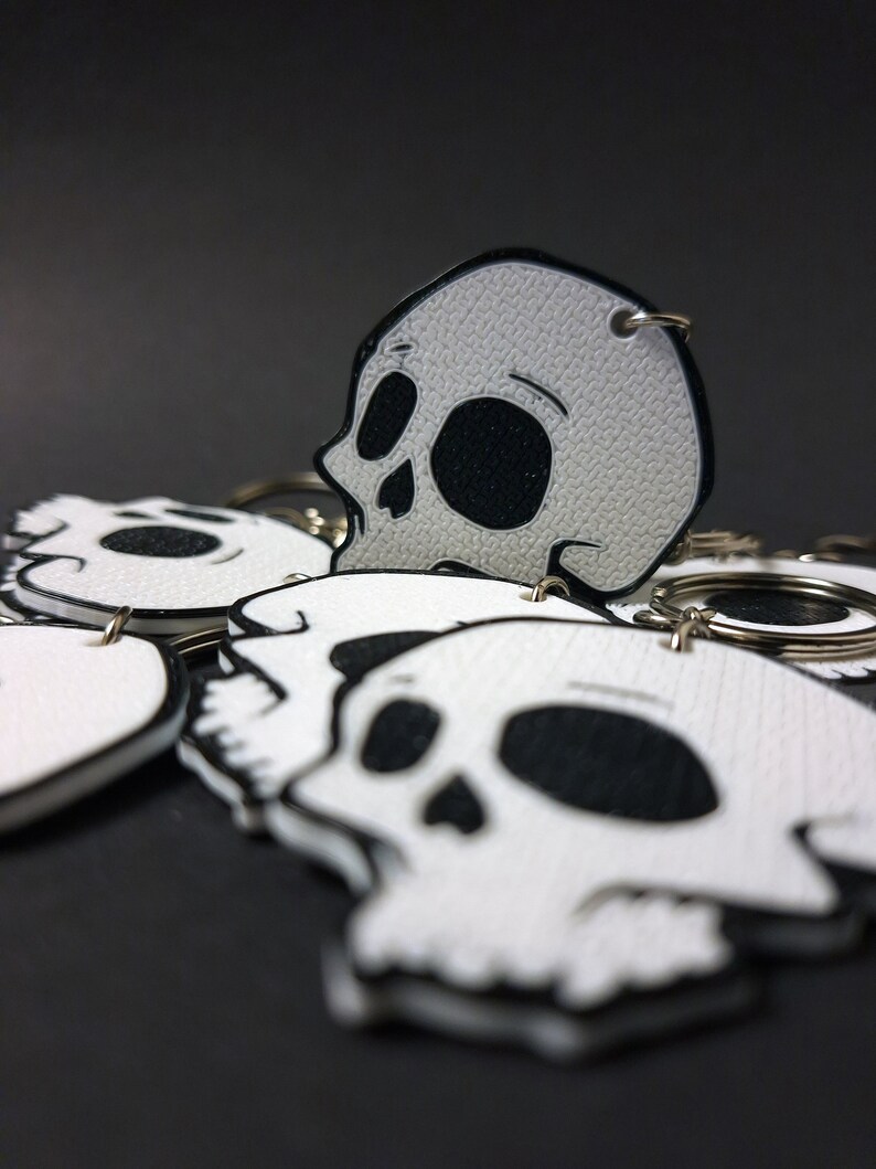 Double-sided 3D printed skull keychain made from durable PET-G material, perfect for gothic fashion lovers. Versatile accessory for both men and women. Add an edgy touch to your style. Nine3D etsy shop with highest quality prints!