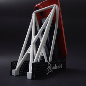 Discover the perfect blend of functionality and style with our racing seat phone holder. Ideal for motorsport enthusiasts, this 3D-printed accessory will change Your desk design and decor. Explore Nine3D shop's unique 3D-printed collection