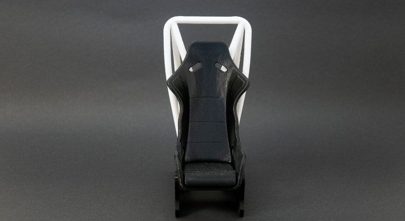 Discover the perfect blend of functionality and style with our racing seat phone holder. Ideal for motorsport enthusiasts, this 3D-printed accessory will change Your desk design and decor. Explore Nine3D shop's unique 3D-printed collection