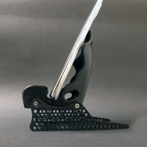 Discover the perfect blend of functionality and style with our racing seat phone holder. Ideal for motorsport enthusiasts, this 3D-printed accessory will change Your desk design and decor. Explore Nine3D shop's unique 3D-printed collection