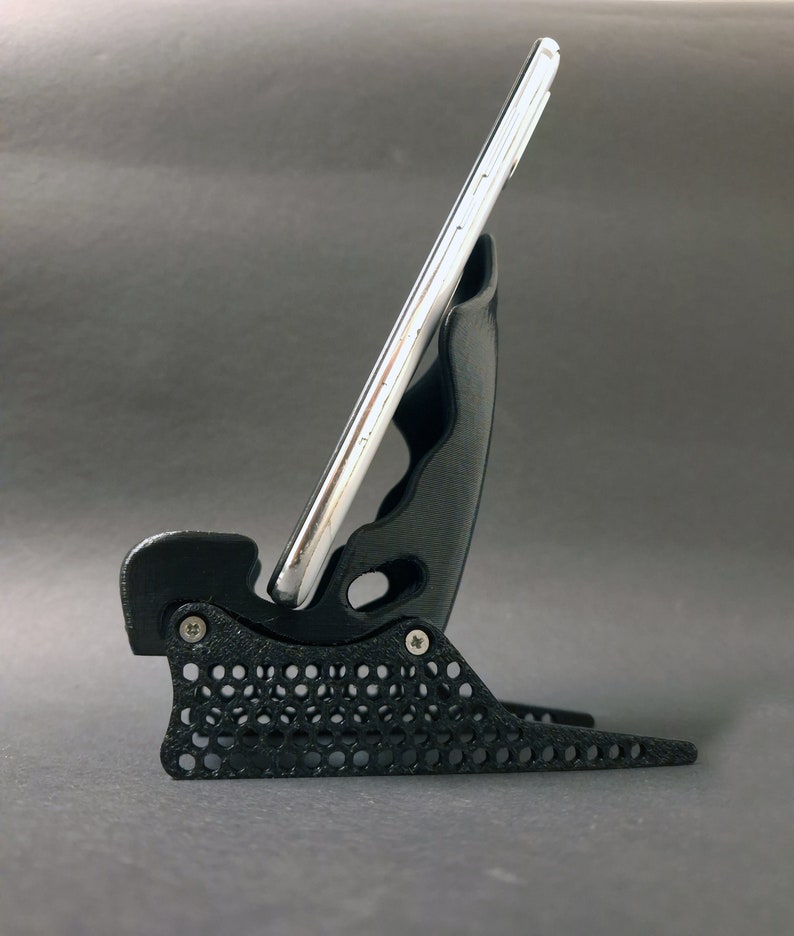 Discover the perfect blend of functionality and style with our racing seat phone holder. Ideal for motorsport enthusiasts, this 3D-printed accessory will change Your desk design and decor. Explore Nine3D shop's unique 3D-printed collection