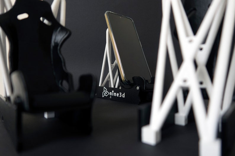 Discover the perfect blend of functionality and style with our racing seat phone holder. Ideal for motorsport enthusiasts, this 3D-printed accessory will change Your desk design and decor. Explore Nine3D shop's unique 3D-printed collection