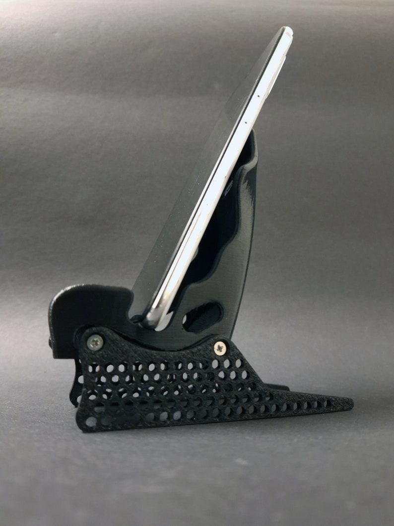 Discover the perfect blend of functionality and style with our racing seat phone holder. Ideal for motorsport enthusiasts, this 3D-printed accessory will change Your desk design and decor. Explore Nine3D shop's unique 3D-printed collection