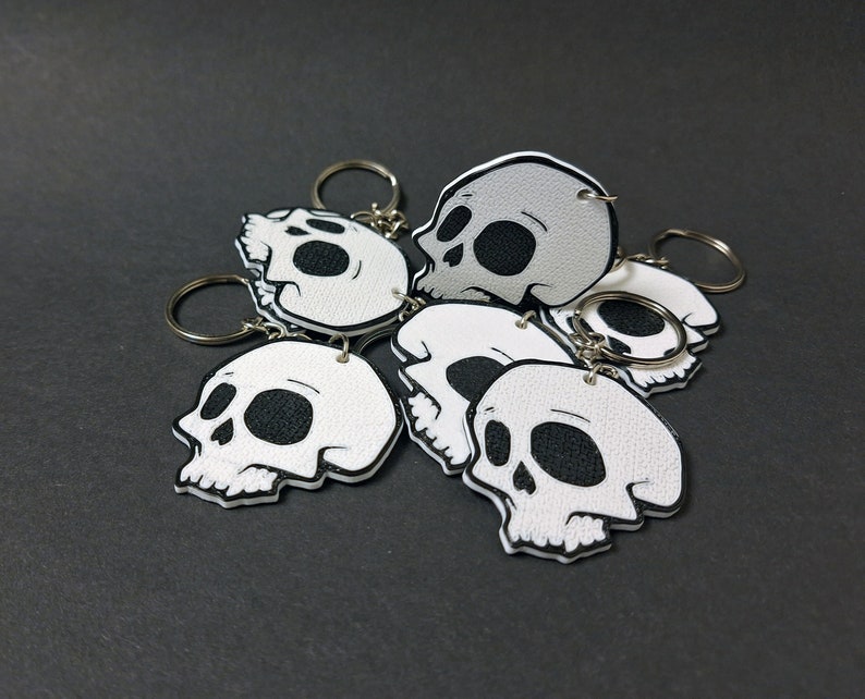 Double-sided 3D printed skull keychain made from durable PET-G material, perfect for gothic fashion lovers. Versatile accessory for both men and women. Add an edgy touch to your style. Nine3D etsy shop with highest quality prints!