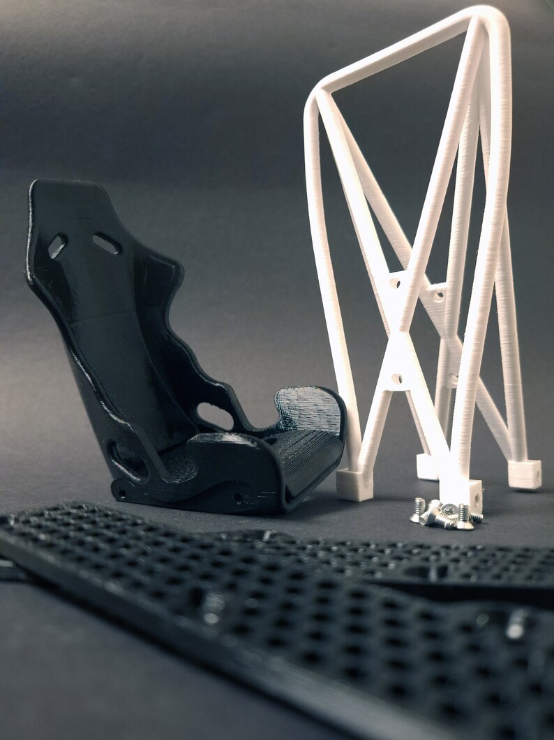 Transform your workspace with this incredible customizable DIY racing seat phone holder kit. It features an unassembled roll cage design that allows you to create a unique and stylish phone stand for your desk. Elevate your workspace today! Nine3D