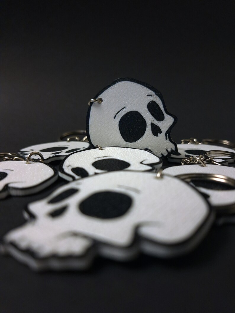 Double-sided 3D printed skull keychain made from durable PET-G material, perfect for gothic fashion lovers. Versatile accessory for both men and women. Add an edgy touch to your style. Nine3D etsy shop with highest quality prints!