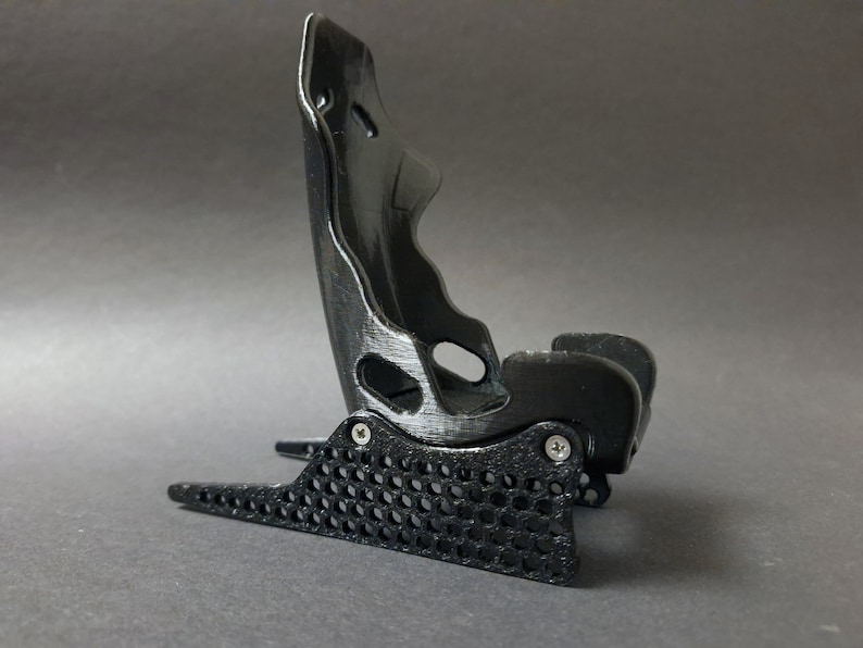 Discover the perfect blend of functionality and style with our racing seat phone holder. Ideal for motorsport enthusiasts, this 3D-printed accessory will change Your desk design and decor. Explore Nine3D shop's unique 3D-printed collection