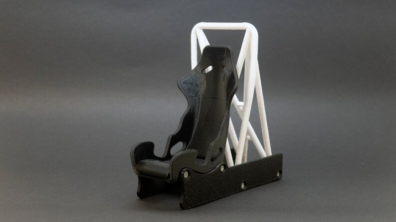 Discover the perfect blend of functionality and style with our racing seat phone holder. Ideal for motorsport enthusiasts, this 3D-printed accessory will change Your desk design and decor. Explore Nine3D shop's unique 3D-printed collection