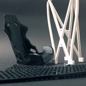 Transform your workspace with this incredible customizable DIY racing seat phone holder kit. It features an unassembled roll cage design that allows you to create a unique and stylish phone stand for your desk. Elevate your workspace today! Nine3D