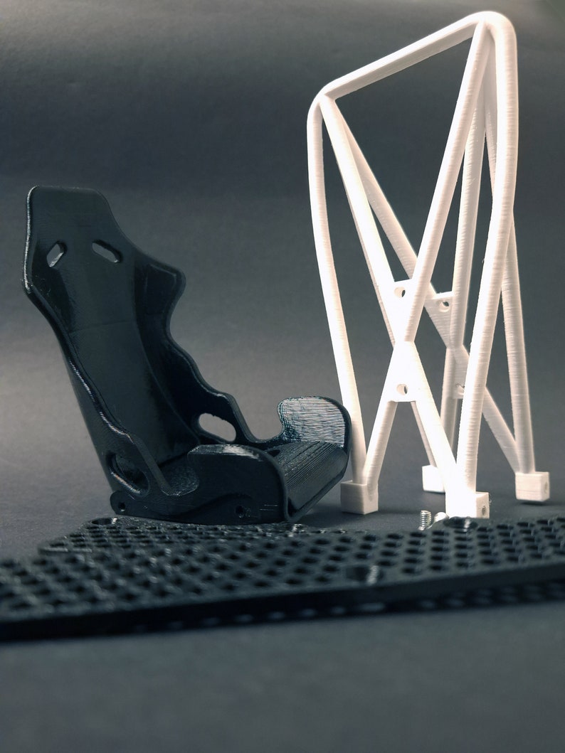 Transform your workspace with this incredible customizable DIY racing seat phone holder kit. It features an unassembled roll cage design that allows you to create a unique and stylish phone stand for your desk. Elevate your workspace today! Nine3D