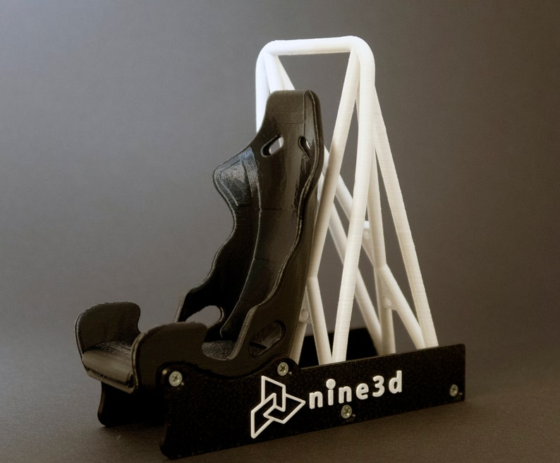 Discover the perfect blend of functionality and style with our racing seat phone holder. Ideal for motorsport enthusiasts, this 3D-printed accessory will change Your desk design and decor. Explore Nine3D shop's unique 3D-printed collection