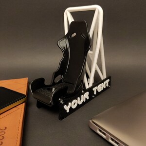 Discover the perfect blend of functionality and style with our racing seat phone holder. Ideal for motorsport enthusiasts, this 3D-printed accessory will change Your desk design and decor. Explore Nine3D shop's unique 3D-printed collection