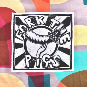 May include: A square fabric patch featuring a black and white linocut-style graphic. The design depicts a sausage on a fork wearing a police helmet, surrounded by a sunburst pattern and the bold text FORK THE PIGS arranged in a circular layout.