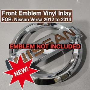 May include: A chrome front emblem vinyl inlay for Nissan Versa models from 2012 to 2014. The word "NISSAN" is visible on the emblem. A red starburst graphic with the word "NEW!" is in the lower left corner. The text "EMBLEM NOT INCLUDED" is also present.