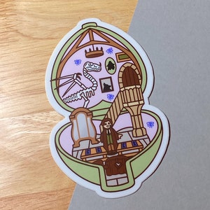 May include: A sticker featuring a whimsical illustration of a dollhouse-like structure. The design includes a dinosaur skeleton, a figure, and architectural details in shades of pink, green, and brown. Decorative butterflies and framed art complete the scene.