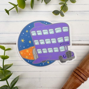 May include: A purple and orange sticker of a flying bus with the text "WAHOO!" on the side. The bus has many windows and is flying through the air with a trail of orange flames behind it.