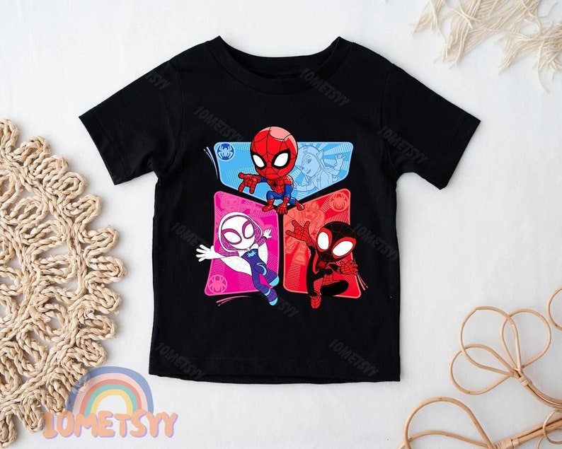May include: Black t-shirt with a graphic print of three cartoon Spider-Man characters. The characters are in different colored squares. The characters are Spider-Man, Spider-Gwen, and Miles Morales.