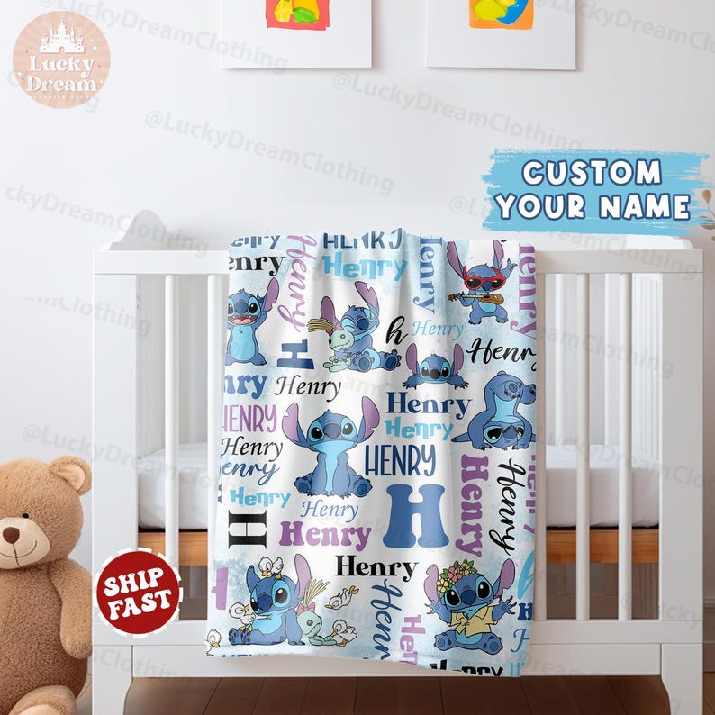 Puede incluir: Una manta de beb&eacute; blanca y azul con un patr&oacute;n repetido de Stitch de Lilo & Stitch. La manta tiene el nombre "Henry" en letras moradas y azules.