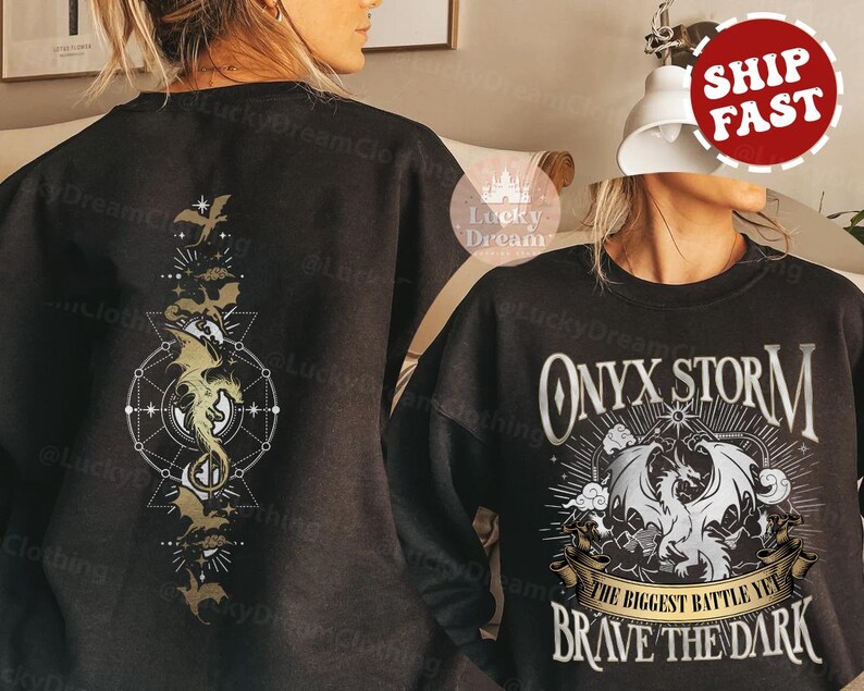 K&ouml;nnte beinhalten: Schwarzer Pullover mit einem goldenen Drachen-Design auf der R&uuml;ckseite und dem Text "ONYX STORM THE BIGGEST BATTLE YET BRAVE THE DARK" auf der Vorderseite.