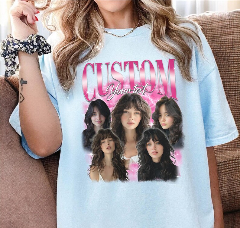 May include: Light blue t-shirt with a custom design. The design features the word "CUSTOM" in pink, with the words "Your text" below it. Below the text are five images of women with long hair.