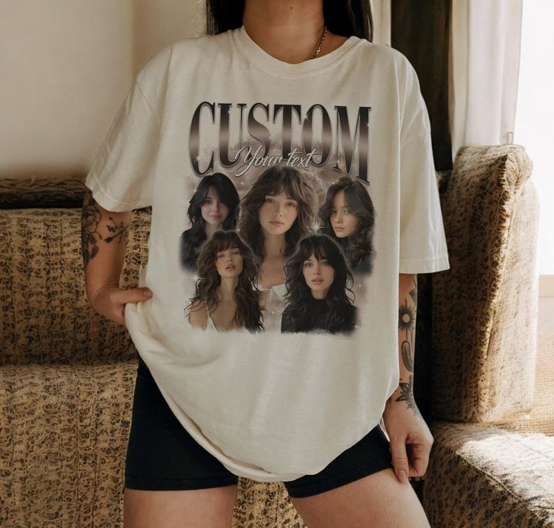 May include: Cream-colored t-shirt featuring the word "CUSTOM" above a graphic of five women. The text "Your text" is below the word "CUSTOM". The women have long hair and are in various poses.