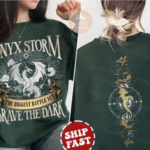 K&ouml;nnte beinhalten: Gr&uuml;nes Sweatshirt mit einem wei&szlig;en Drachen-Motiv und dem Text "ONYX STORM THE BIGGEST BATTLE YET BRAVE THE DARK".