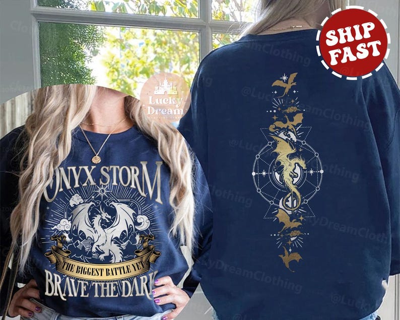 K&ouml;nnte beinhalten: Ein marineblauer Sweatshirt mit einem wei&szlig;en Drachen-Motiv und dem Text "Onyx Storm The Biggest Battle Yet Brave The Dark". Die R&uuml;ckseite des Sweatshirts zeigt ein goldenes Drachen-Motiv mit einem geometrischen Design.