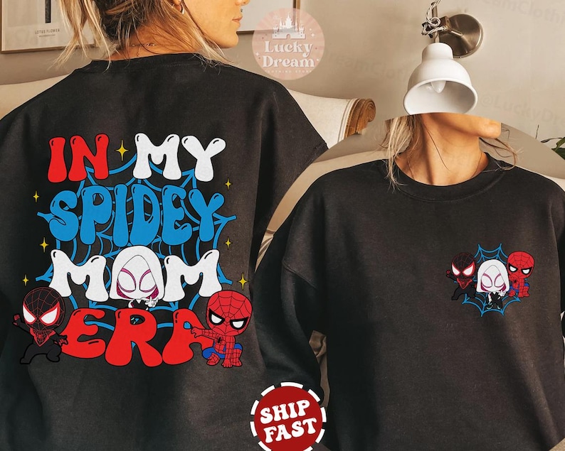May include: Black sweatshirt with the text "In My Spidey Mom Era" in colorful letters and a spider web design. There are three cartoon spider-man characters on the front of the shirt.