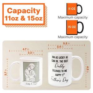 K&ouml;nnte beinhalten: Wei&szlig;e Keramiktasse mit einer schwarz-grauen Illustration von Vater und Sohn. Die Tasse hat einen schwarzen Henkel und tr&auml;gt die Aufschrift "I'm as lucky as can be. The best Daddy belongs to me. Happy 1st Father's Day". Die Tasse ist 11,4 cm hoch und 8,6 cm breit. Die Tasse ist in den Gr&ouml;&szlig;en 11 oz und 15 oz erh&auml;ltlich.