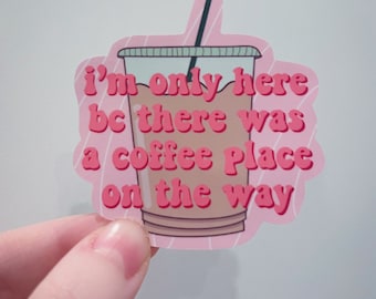 May include: Pink sticker with a cartoon iced coffee cup and the text "i'm only here bc there was a coffee place on the way"
