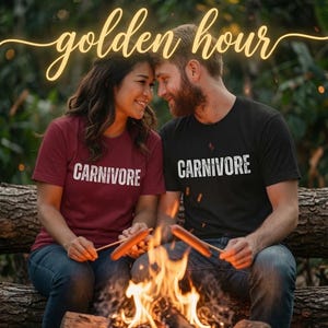May include: A maroon t-shirt and a black t-shirt, each featuring the word CARNIVORE in white distressed lettering across the chest. The shirts are worn with blue denim jeans, and the text golden hour is displayed in a cursive yellow font above.