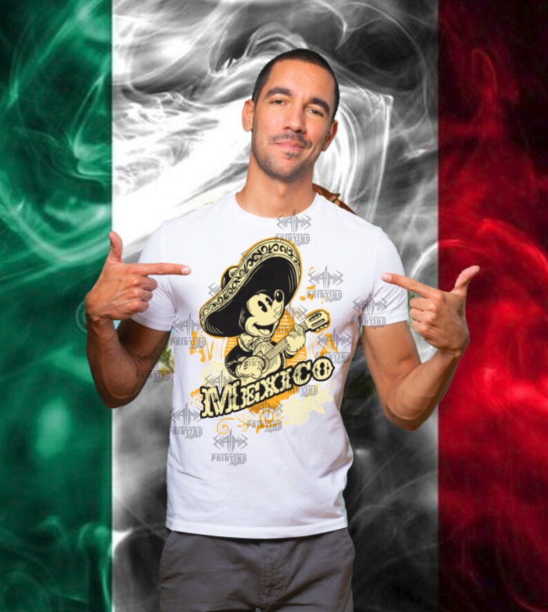 May include: White t-shirt featuring a cartoon Mickey Mouse playing a guitar and wearing a sombrero. The word "Mexico" is printed below the image. The background is a stylized Mexican flag.