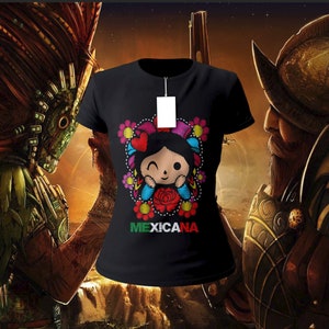 May include: Black t-shirt featuring a colorful embroidered design of a winking doll with flowers and the word "MEXICANA" in green, red, and blue. The shirt has a blank tag attached. The background features illustrations of historical figures.