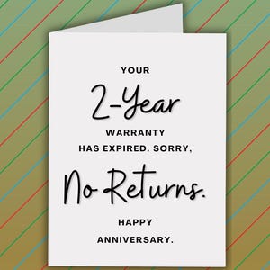 Pode incluir: Um cart&atilde;o branco com o texto "YOUR 2-Year WARRANTY HAS EXPIRED. SORRY, No Returns. HAPPY ANNIVERSARY." O cart&atilde;o tem um interior branco e est&aacute; colocado sobre um fundo com listras diagonais em verde, azul e vermelho.