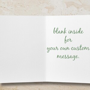 K&ouml;nnte beinhalten: Eine offene Gru&szlig;karte mit leerem Innenraum. Die rechte Seite der Karte zeigt gr&uuml;nen Schreibschrifttext mit der Aufschrift "blank inside for your own custom message."