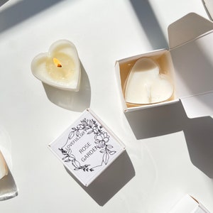 May include: White heart-shaped candles in boxes with the text "Lovefullgift Rose Garden" and "Lovefullgift Daisy" printed on the boxes.