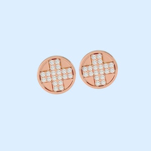 May include: A pair of rose gold stud earrings with a cross design set with small diamonds.