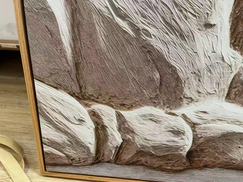 May include: Close-up of a textured abstract painting in a wooden frame. The artwork features a palette of neutral tones, including shades of brown, beige, and white, creating a sense of depth and dimension. The brushstrokes are visible, adding to the tactile quality.