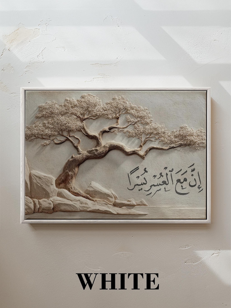 May include: A framed, three-dimensional artwork featuring a detailed relief of a tree with textured leaves and branches. The artwork is in neutral tones, with the word "WHITE" at the bottom. Arabic script is also visible.