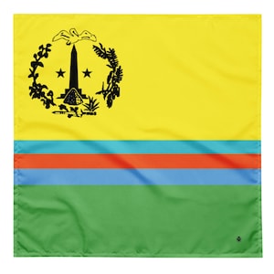 Op de afbeelding: Een vierkante, gele bandana met een zwart embleem in de linkerbovenhoek, met een centrale obelisk, sterren en een krans. Daaronder scheiden horizontale strepen in teal, oranje en blauw de gele bovenkant van een groene onderkant.