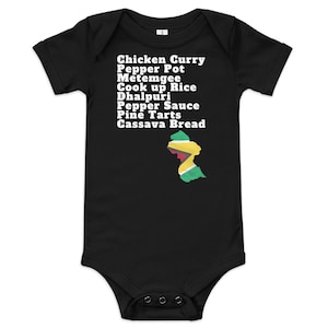 May include: Black baby bodysuit with a white outline of the Guyana flag and a list of Guyanese foods: Chicken Curry, Pepper Pot, Metemgee, Cook up Rice, Dhalpuri, Pepper Sauce, Pine Tarts, Cassava Bread.