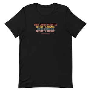 以下が含まれることがあります： 黒いTシャツ。オレンジ、青、黄色のテキストで「WHAT CAN BE ASSERTED WITHOUT EVIDENCE CAN BE DISMISSED WITHOUT EVIDENCE」という引用句が書かれています。この引用句はクリストファー・ヒッチェンズによるものです。