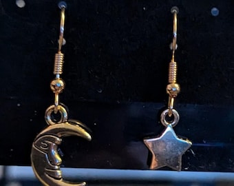 Moon and Star paired Celestial Earrings, dangling on a Fishhook style earing hook.