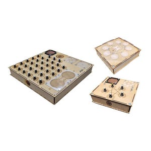 Op de afbeelding: Drie houten dozen met verschillende ontwerpen. De eerste doos heeft een raster van kleine knoppen, de tweede doos heeft een cirkelvormig ontwerp met een centrale knop en de derde doos heeft een stervormig ontwerp met vijf knoppen.