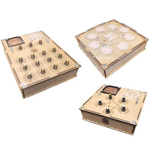 Op de afbeelding: Drie houten dozen met verschillende puzzelmechanismen. De eerste doos heeft een raster van 16 knoppen, de tweede doos heeft een cirkelvormig patroon van 8 knoppen en de derde doos heeft een stervormig patroon van 5 knoppen.