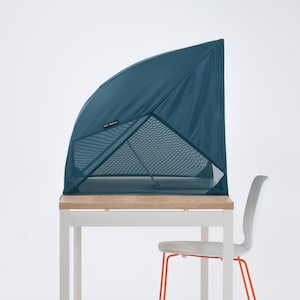Peut inclure: Une tente de bureau pop-up bleu sarcelle, offrant intimité et un sentiment d'enveloppement. La tente est faite de maille et de tissu et est installée sur un bureau blanc avec un plateau en bois. Une chaise blanche avec des pieds orange est au premier plan.