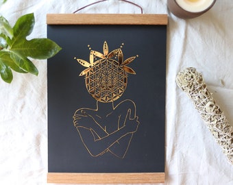 Könnte beinhalten: Ein schwarzer gerahmter Druck mit einem goldenen geometrischen Design einer Person, die sich selbst umarmt. Das Design erinnert an eine Blume oder ein Mandala.