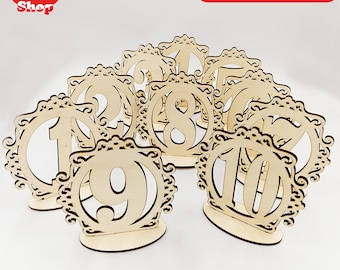 May include: Ten laser cut wooden table numbers with ornate frames. The numbers are in a circle and are arranged in a semi-circle.