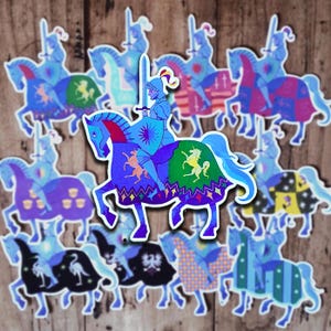 Peut inclure: Une collection d'autocollants découpés représentant un chevalier en armure bleue montant un cheval. Le cheval est orné de couvertures colorées à motifs affichant divers symboles comme des licornes, des étoiles et des écussons.