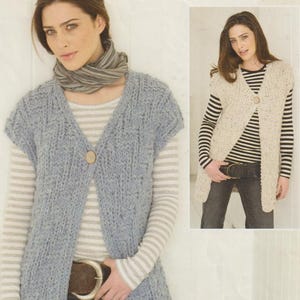 May include: A light blue, long knitted vest with a V-neck and a single wooden button closure. The vest is worn over a striped shirt and jeans. A smaller image shows a similar vest in a cream color.